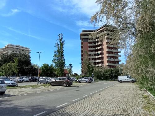 un parking avec des voitures garées devant un bâtiment dans l'établissement casa di Baia, à Pesaro