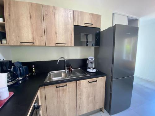 une cuisine avec un évier et un réfrigérateur dans l'établissement Maison proche du centre Pornic, à Pornic