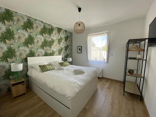 - une chambre avec un lit blanc et un mur de plantes dans l'établissement Maison proche du centre Pornic, à Pornic