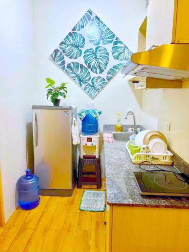a kitchen with a sink and a refrigerator at SEAWIND CONDOMINIUM RENTALS by AGL in Davao City