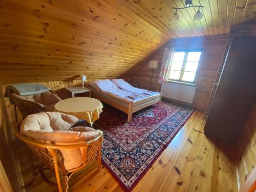 a room with a bed and a table in a cabin at Ostoja nad Bugiem in Janów Podlaski