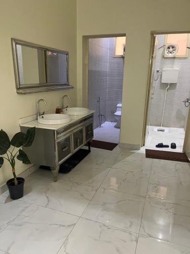 y baño con 2 lavabos y ducha. en شليه en Hafr Al Batin