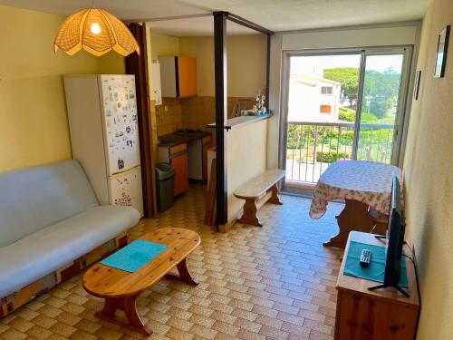 Il comprend une cuisine équipée d'un canapé, d'une table et d'un réfrigérateur. dans l'établissement C19 Saint Martin, au Cap d'Agde