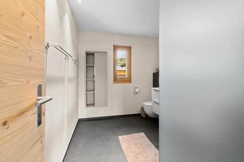 a bathroom with a toilet and a door at Stilvolle 4.5 Zimmer Wohnung nahe der Talstation in Vella