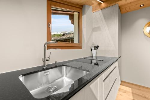 uma cozinha com um lavatório e uma janela em Stilvolle 4.5 Zimmer Wohnung nahe der Talstation em Vella