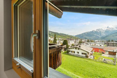 a window with a view of the mountains at Stilvolle 4.5 Zimmer Wohnung nahe der Talstation in Vella