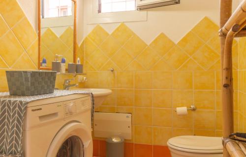 a bathroom with a washing machine and a toilet at Casa Michela in Palau
