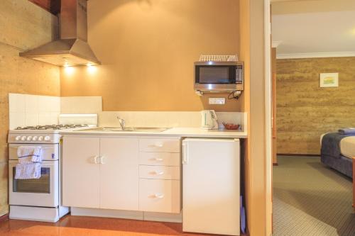 a small kitchen with a sink and a microwave at The Koorabup Motel in Denmark