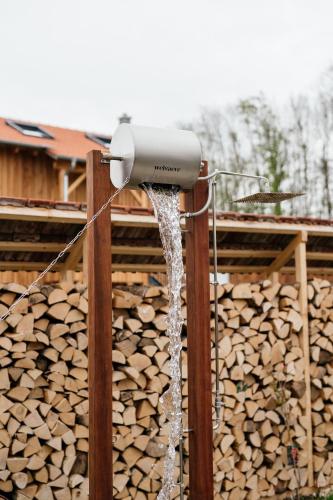 a water fountain in front of a pile of wood at Raschbrunnenhof - Ökolandbau & Erholung in Haunsheim