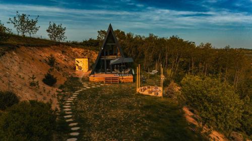 Sunny A Frame in National Park Fruska Gora - Vrdnik في فردنيك: منزل صغير جالس فوق تلة