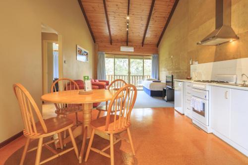 a kitchen and dining room with a table and chairs at The Koorabup Motel in Denmark