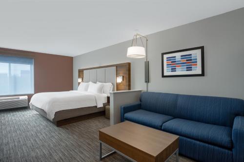 Habitación de hotel con cama y sofá en Holiday Inn Express & Suites Clinton, an IHG Hotel, en Clinton