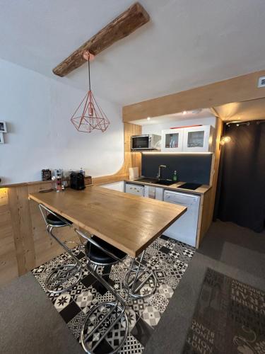a kitchen with a wooden table in a room at Appartement Cosy Les arcs 1800 in Bourg-Saint-Maurice