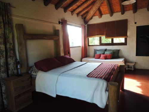 een slaapkamer met 2 bedden en een raam bij Residencia en Casa de artista in Vistalba