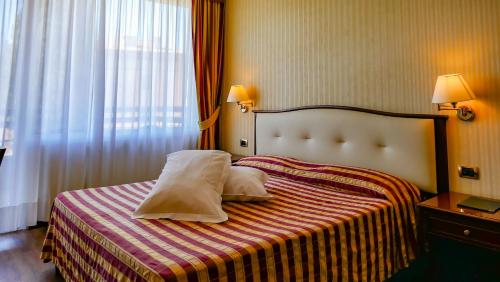 a hotel room with a bed with two pillows on it at Hotel Benaco Garda ***S in Garda