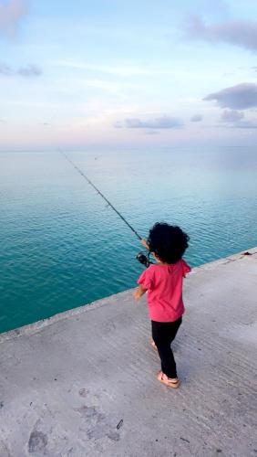 a little girl holding onto a string near the water at Atholhu Residence in Fehendhoo