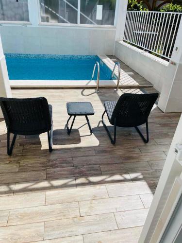 two chairs and a table in front of a pool at Lavanda 3 in Njivice