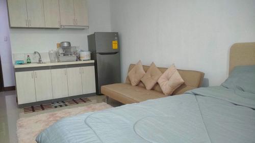 ein Schlafzimmer mit einem Bett und einem Sofa sowie eine Küche in der Unterkunft Saekyung 956 Condominium in Lo-oc