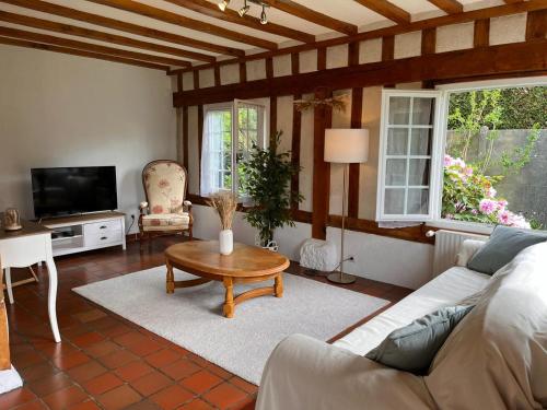 ein Wohnzimmer mit einem Sofa und einem Couchtisch in der Unterkunft Maison 110 m² cosy au calme avec jardin de 1000 m² in Pont-Audemer