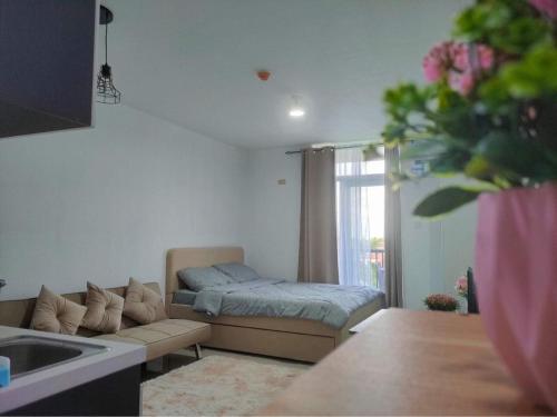 ein Wohnzimmer mit einem Sofa und einem Bett in der Unterkunft Saekyung 956 Condominium in Lo-oc