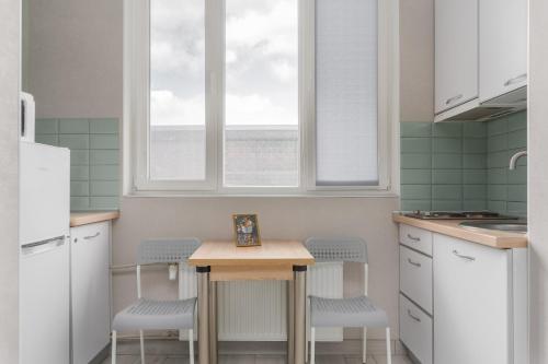 a kitchen with a small table and two chairs at Бірюзова студія, Південний вокзал 5 хвилин in Kharkiv