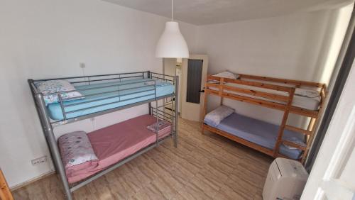 Habitación pequeña con 2 literas y lámpara. en Historic Malaga Centro Rooms, en Málaga