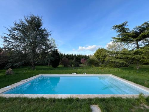 - une piscine sur gazon dans une cour dans l'établissement La clé des champs - Les Grais 1H10 de Paris, à Bazoches-sur-le-Betz