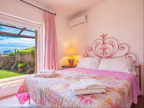 Ένα ή περισσότερα κρεβάτια σε δωμάτιο στο Sardinia Family Villas - Villa Carmen with sea view and pool