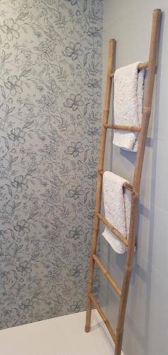 a towel ladder in a bathroom with a floral wallpaper at Maison de plage Manoga in Saint-Germain-sur-Ay