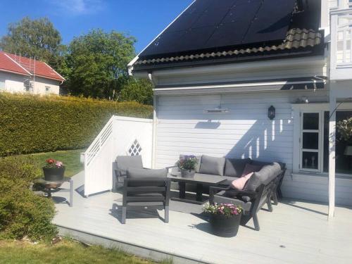 a patio with a table and chairs on a house at Grand villa at Nøtterøy in Nøtterøy