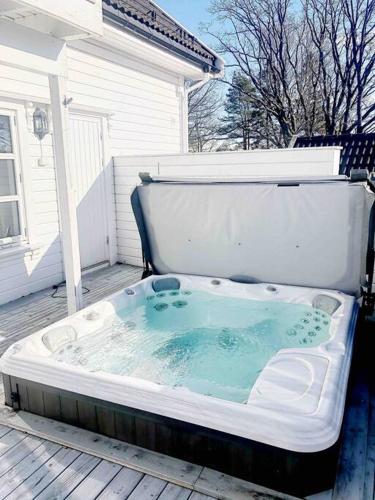a hot tub sitting on a deck in front of a house at Grand villa at Nøtterøy in Nøtterøy