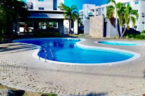 - une piscine d'eau bleue dans un complexe dans l'établissement luxurious 3 bedroom apt w pool, à Santiago de los Caballeros