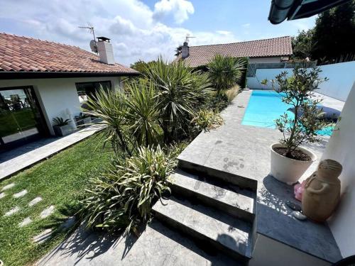 a backyard with a swimming pool and a house at Maison contemporaine Socoa in Urrugne