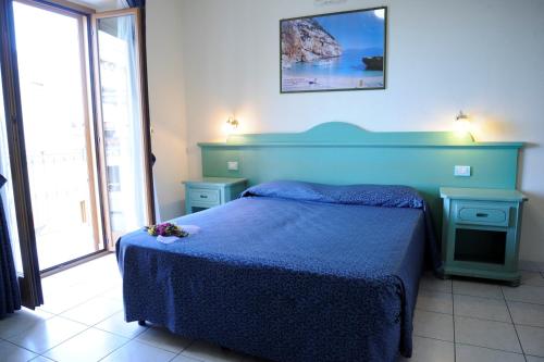 a bedroom with a blue bed with flowers on it at Hotel San Francisco in Cala Gonone
