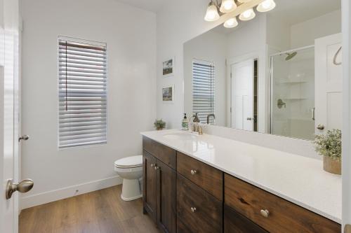 ein Badezimmer mit einem Waschbecken, einem WC und einem Spiegel in der Unterkunft Bear Lake Meadow View in Garden City