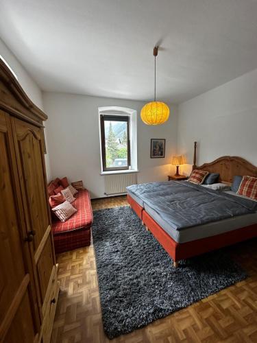 um quarto com uma cama, um sofá e uma janela em Mountain view em Mayrhofen