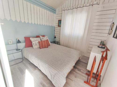 een kleine slaapkamer met een bed en een raam bij La Caravelle - Chalet t2 climatisé lit queen size ou twin in Tarbes