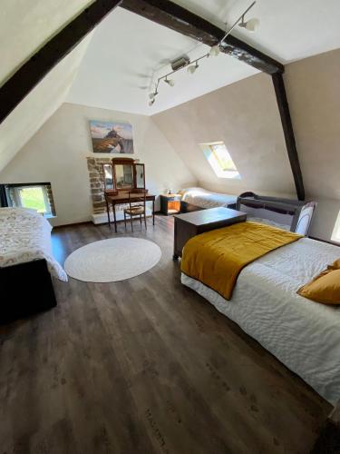 - une chambre mansardée avec un lit et une table dans l'établissement Gite Cottage Le Giré, à Hudimesnil