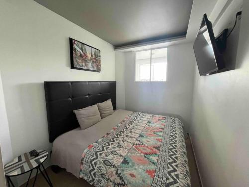 Dormitorio pequeño con cama y TV en STUDiO RAYON en Morelia