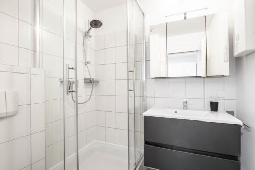 a white bathroom with a shower and a sink at Yellow&Black NEU Designer Apartment Bielefeld City WLAN kostenloser Parkplatz in Bielefeld