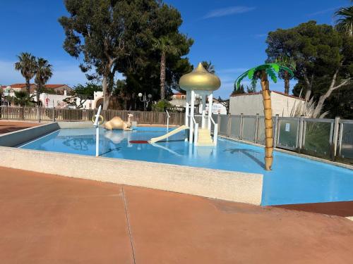 une piscine avec un parc aquatique avec un toboggan aquatique dans l'établissement Camping la palmeraie 4* mobil home 3 chambres-6personnes, à Torreilles