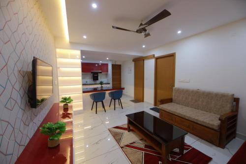 una sala de estar con un sofá y una mesa en THE ELITE DWELL APPARTMENT, en Trivandrum