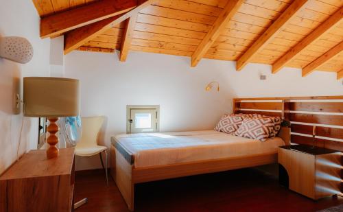 a bedroom with a bed in a room with wooden ceilings at Villa Dioni in Agios Nikitas