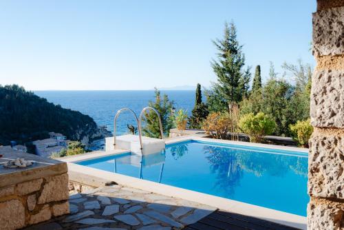 a swimming pool with a view of the ocean at Villa Dioni in Agios Nikitas