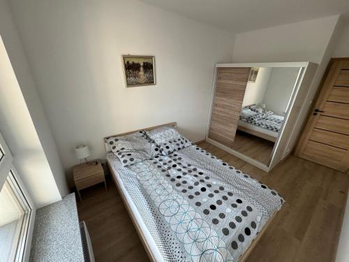 a bedroom with a bed and a large mirror at Apartament Mike in Giżycko