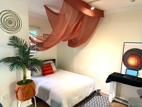 - une chambre avec un lit et une plante en pot dans l'établissement The Downtown Suite, à Los Angeles