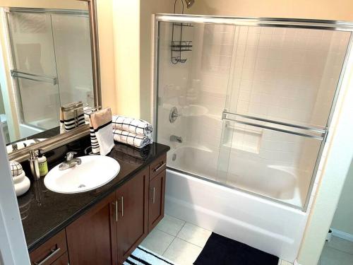 een badkamer met een douche, een wastafel en een bad bij The Downtown Suite in Los Angeles