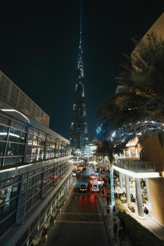a view of the spire of a tall building at night at Pleasure Pod Hostel Rolla Street in Dubai