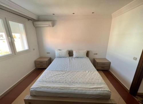 una camera da letto con un grande letto con due comodini di Villa avec piscine privée a El Jadida