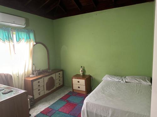 聖瑪麗的住宿－Seaview Villa，一间卧室配有一张床、梳妆台和镜子